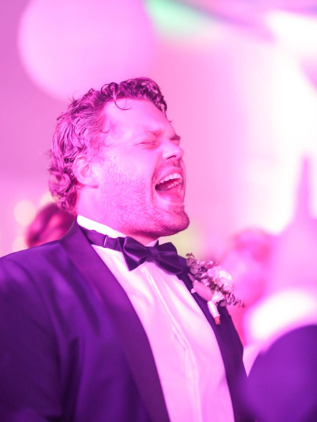 Brudgummen sjunger med i rosa ljus